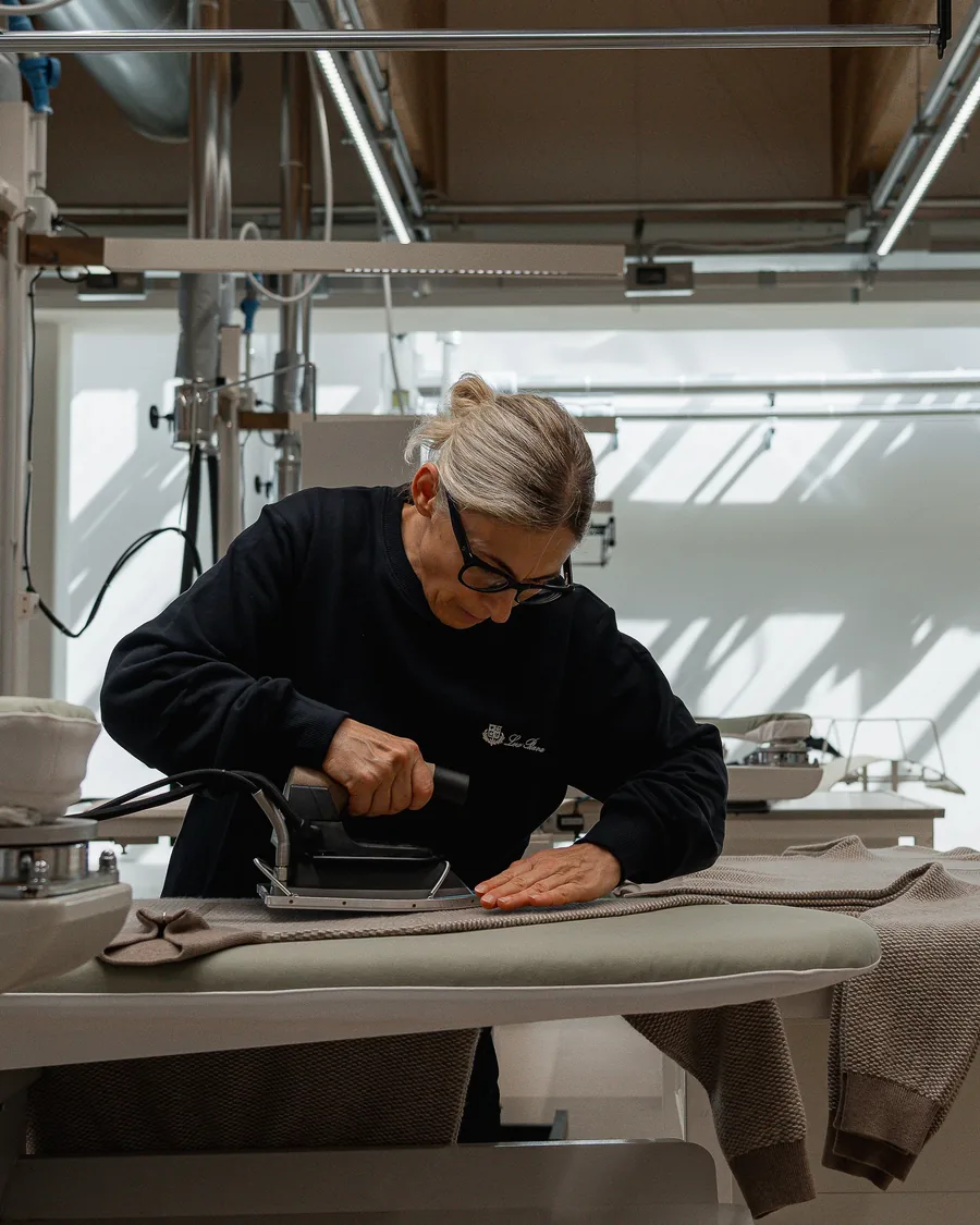 Kunsthandwerkerin von Loro Piana bügelt in Ghemme ein Strickteil am Finishing-Tisch